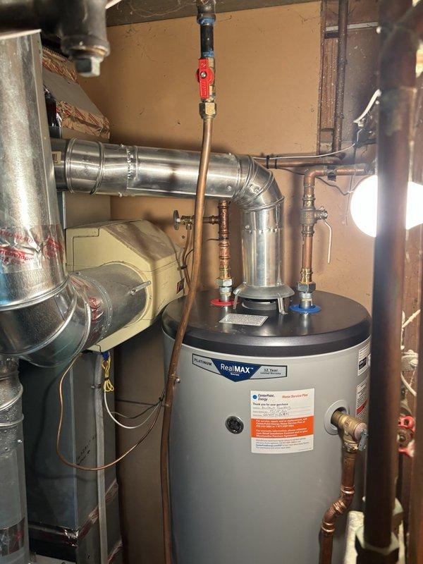 Responded to inspection correction notice for water heater vent connector that was back-pitched and failed to meet code requirements. Cut and repositioned the vertical vent pipe on the water heater to achieve proper 1/4" per foot pitch as required by building code. Verified correct pitch using level and documented the corrected installation with photographs for submission to the building inspector.