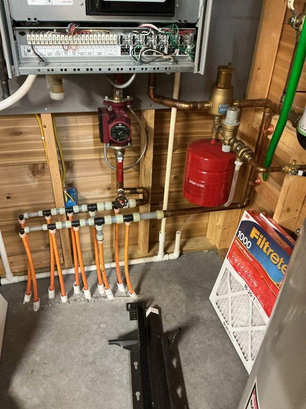 Completed annual maintenance on 11-year-old furnace and boiler system. Performed comprehensive tune-up including cleaning of routine components, thorough heat exchanger inspection, and testing of all operational controls and safety devices. Serviced hydronic heating system with red circulator pump and expansion tank, verifying proper operation of manifold distribution system with PEX piping. Both furnace and boiler tested under operating conditions and confirmed running efficiently with no issues detected.