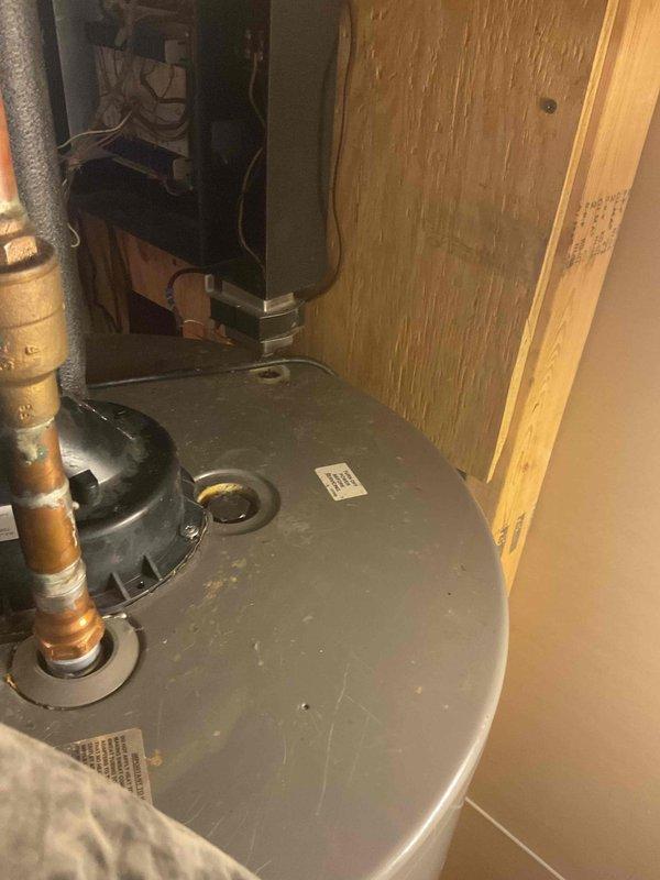Responded to service call for anode rod replacement on residential tanked water heater. Upon arrival, attempted to remove existing anode rod using standard ratchet and impact wrench, but the anode rod bolt was seized and could not be broken free with available tools on truck. Documented existing water heater installation and condition with photos. Customer was informed that specialized equipment would be required to complete the anode rod removal and replacement due to the severely corroded and seized fastener.