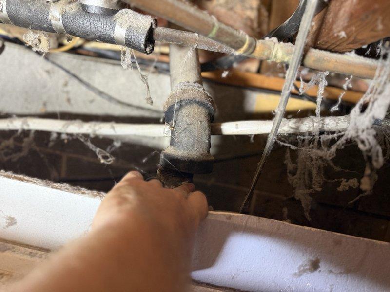 Responded to a non-emergency plumbing leak in the basement area behind the washer and dryer location. Upon inspection, identified an active leak at the kitchen stack connection point in the crawl space, with water dripping from compromised pipe fittings where PVC and metal piping intersect. The broken kitchen stack assembly showed signs of age, wear, and deterioration at multiple connection points. Documented the leak location and extent of damage with photographs showing the affected plumbing infrastructure and surrounding wooden framing. Coordinated with sales team to schedule an estimate for complete kitchen stack replacement and water treatment system evaluation, as the scope of repairs required exceeds standard service call parameters.