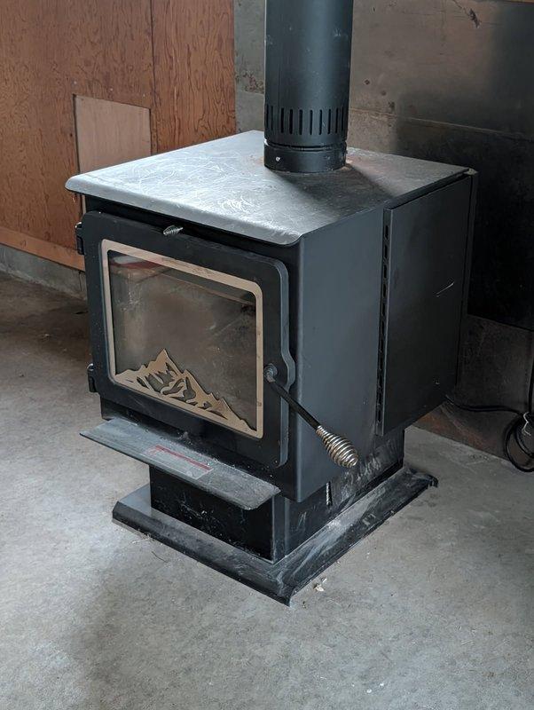 Responded to service call for wood stove disconnection due to homeowners insurance coverage complications. Successfully unplugged electrical connection and disconnected chimney pipe from black wood-burning stove unit located in basement utility area. Advised customer that complete sealing of the chimney penetration would require return visit with 7-inch chimney cap and appropriate silicone sealant materials, with estimate to follow from parts department for required components and installation.