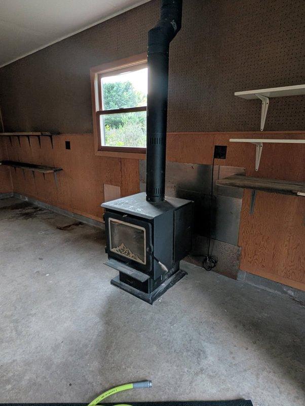 Responded to service call for wood stove disconnection due to homeowners insurance coverage complications. Successfully unplugged electrical connection and disconnected chimney pipe from black wood-burning stove unit located in basement utility area. Advised customer that complete sealing of the chimney penetration would require return visit with 7-inch chimney cap and appropriate silicone sealant materials, with estimate to follow from parts department for required components and installation.