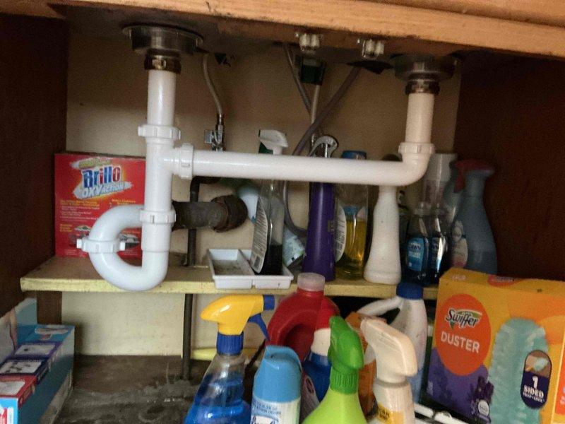 Responded to service call for leaking tubular piping and basket strainers under double-basin kitchen sink. Upon inspection, determined that existing under-sink drainage assembly had failed and required complete replacement. Removed deteriorated tubular piping, P-traps, and both basket strainers from the double-basin stainless steel sink installation. Installed two new basket strainers with proper sealing, connected new PVC tubular piping including end waste assembly and trap configuration suitable for dual-basin setup. Verified all connections were secure and properly aligned. Conducted operational testing by filling both sink basins and releasing water to confirm proper drainage flow and verify leak-free performance of all newly installed components. System functioning as designed with no leaks detected.