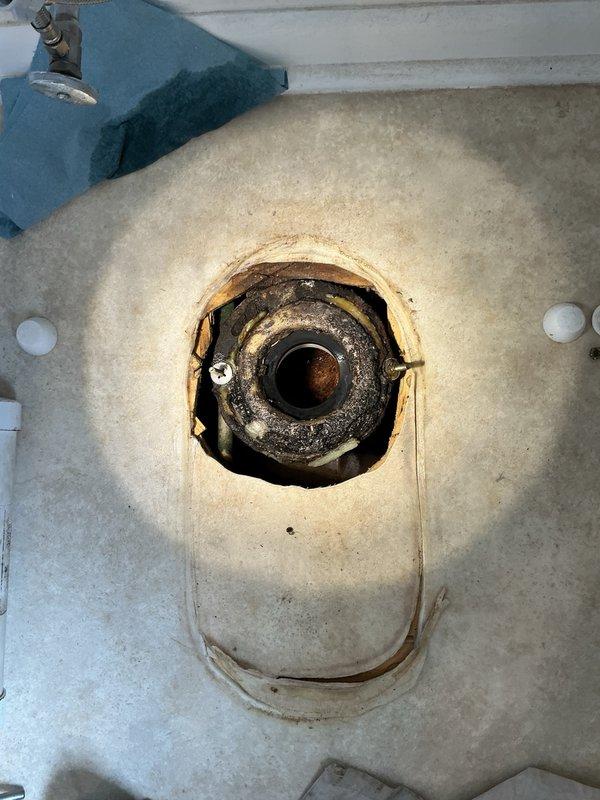 Responded to emergency call for toilet leaking through ceiling into kitchen below. Upon inspection, identified failed wax ring as source of leak. Removed toilet and assessed flange condition—cast iron flange found to be structurally sound with no replacement required at this time. Installed new wax ring, properly reset toilet to ensure proper seal, and applied caulking along front base for added stability. Advised property owner that future leak issues may necessitate flange replacement and subfloor repair due to age of existing components.