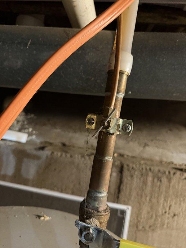 Returned to property to remove obsolete piercing valve from copper water line that previously supplied a humidifier. The piercing valve was successfully disconnected and removed from the vertical copper pipe assembly, completing the cleanup work following the previous day's installation. All connections were left secure and the plumbing system restored to proper working condition.