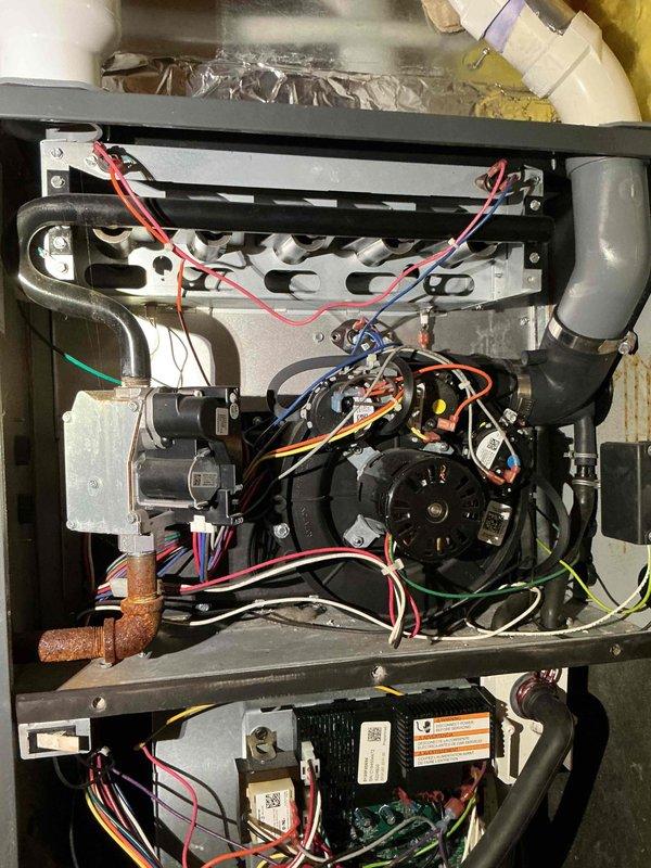 Completed annual furnace tune-up on 10-year-old gas heating unit. Performed standard maintenance procedures including inspection of all mechanical and electrical components, blower motor assembly, heat exchanger, and gas valve connections. During inspection, identified moisture infiltration issue originating from fresh air intake pipe, with water intermittently dripping onto gas valve and internal black iron piping. No active pooling or continuous dripping observed at time of service, indicating sporadic occurrence. Documented condition with photographs showing affected areas including ductwork connections and internal furnace components. Unit remains fully operational with proper heating function confirmed. Created detailed estimate for moisture remediation and informed property owner of findings and recommended corrective action to prevent potential component deterioration or safety concerns.