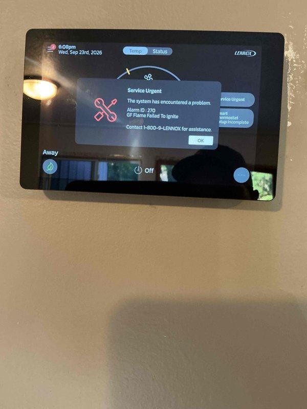Responded to no heat call on Lennox furnace displaying Alarm ID 270 "GP Flame Failed To Ignite" error code on thermostat. Removed burner access panel and cleaned flame sensor to address ignition failure. System successfully ignited and maintained flame with burner cover removed, confirming proper combustion and heating operation for 20 minutes. However, flames extinguished when burner cover was reinstalled, indicating potential pressure switch issue or combustion air supply problem. Visually inspected fresh air intake at burner chamber with no visible obstructions found. Air intake and exhaust terminations located on roof were not accessible during this visit for thorough inspection. Unit operates and heats normally only with burner cover removed, suggesting improper pressure differential or combustion air flow restriction when cabinet is sealed. Follow-up service call required to inspect roof-mounted intake and exhaust venting system, verify proper termination clearances, check for bl