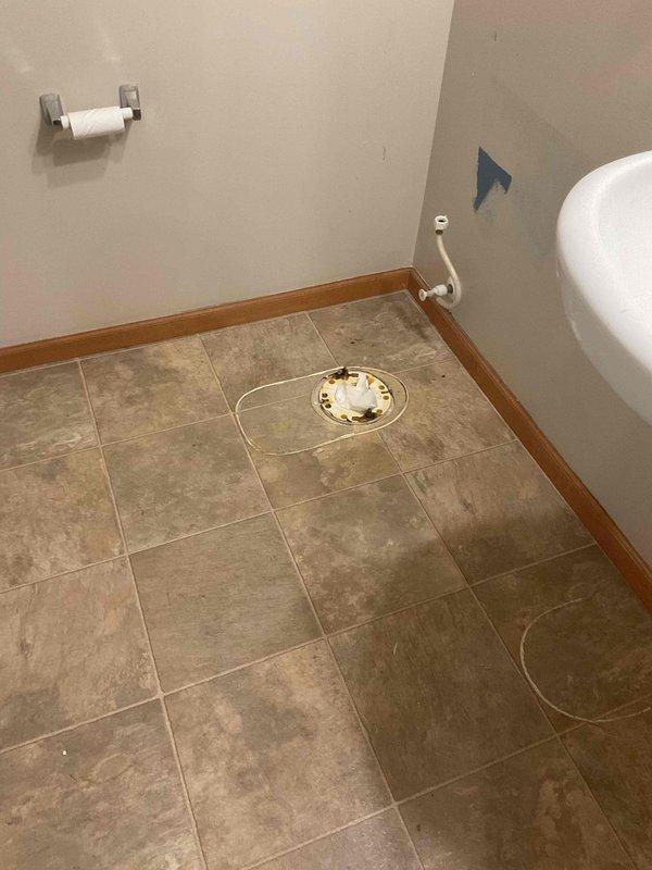 Disconnected and removed toilet and sink fixtures from bathroom in preparation for scheduled flooring installation. Shut off refrigerator water supply line to prevent interference with floor work. All plumbing fixtures were safely disconnected and set aside to allow contractor access for tile replacement.