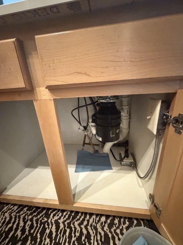 Responded to service call for garbage disposal installation. Removed existing disposal unit and installed customer-supplied replacement garbage disposal beneath kitchen sink. Replaced deteriorated P-trap assembly with new components due to continuous leaking from old trap. Connected disposal unit to sink mounting assembly and verified proper electrical connection. Tested disposal operation and drain flow to ensure proper functionality. All plumbing connections sealed and verified leak-free upon completion.