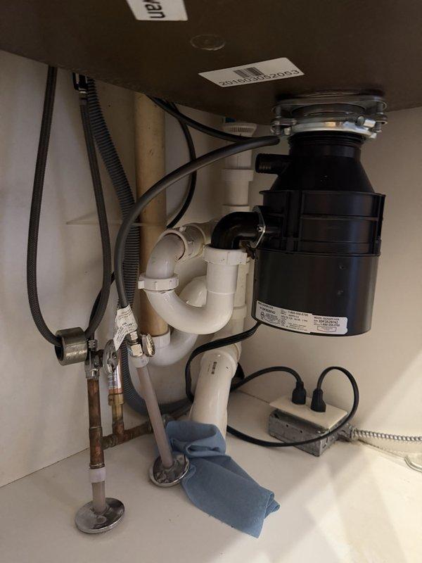 Responded to service call for garbage disposal installation. Removed existing disposal unit and installed customer-supplied replacement garbage disposal beneath kitchen sink. Replaced deteriorated P-trap assembly with new components due to continuous leaking from old trap. Connected disposal unit to sink mounting assembly and verified proper electrical connection. Tested disposal operation and drain flow to ensure proper functionality. All plumbing connections sealed and verified leak-free upon completion.