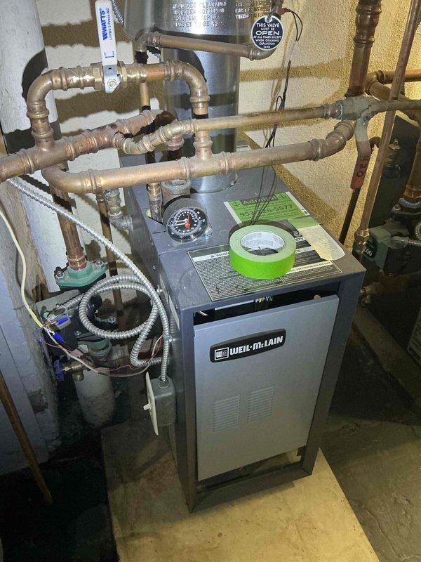 Responded to service call for Weil-McLain boiler system with active water leaks. Upon inspection, found disconnected radiator supply line at floor level and failed radiator valve causing system to leak when operated. Documented existing conditions including aged copper piping with significant corrosion and deterioration throughout distribution system. Assessed boiler unit, circulation components, and venting system. Photographed installation for estimate preparation. Recommended complete repair of broken radiator line, replacement of defective radiator valve, and evaluation of additional piping concerns due to advanced age and condition of system components.