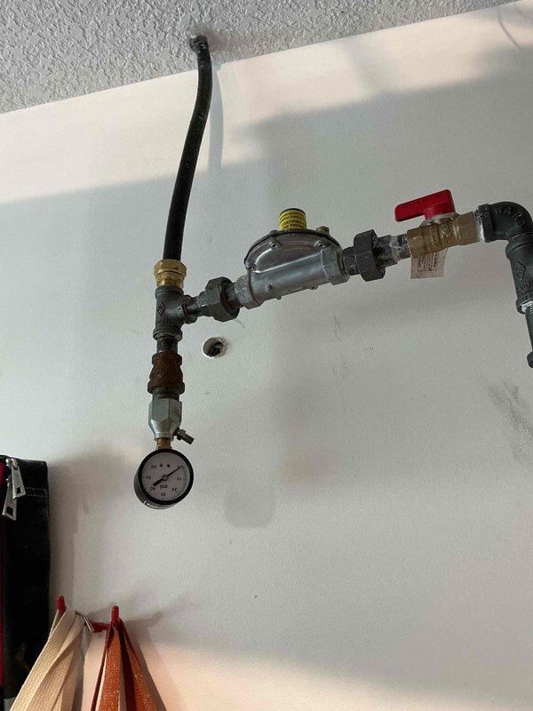 Responded to call back on newly installed garage heater where gas line pressure had dropped from 30 psi at initial installation to 20 psi. Performed comprehensive leak detection using gas probe on all joints and connections throughout the gas line system with no leaks detected. Opened gas line from meter, started garage heater unit, and verified proper operation and heating function. System tested and confirmed operational with all safety protocols observed.