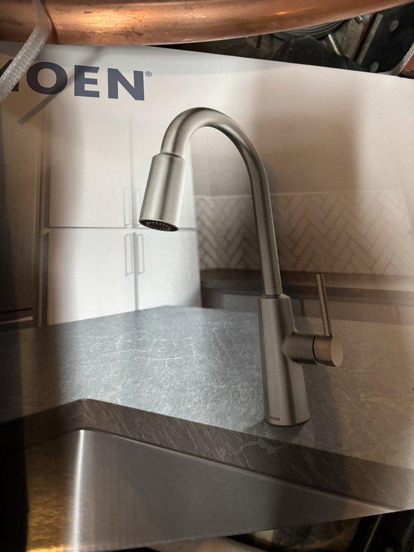 Installed customer-supplied kitchen faucet and soap dispenser. Removed existing fixture and installed new single-handle faucet with pull-down spray head in brushed nickel finish. Connected water supply lines to existing shut-off valves. Tested installation by running water for over five minutes to verify proper operation and check for leaks. No leaks detected. Faucet left in service and fully operational.