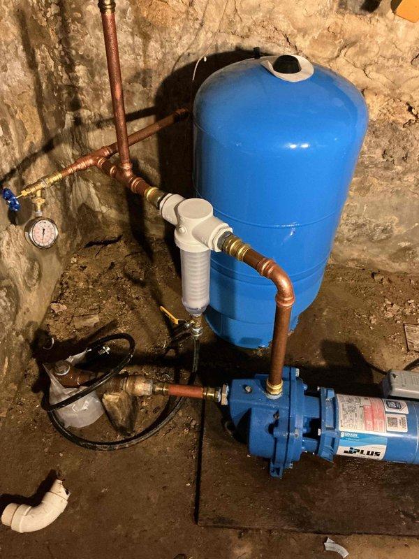 Removed and replaced failing well pressure tank with new WX 202 20-gallon pressure tank assembly in basement utility area. Installed new tank utilizing existing tee assembly and connections to maintain proper water flow and prevent pump motor burnout. Additionally installed spin down sediment filter and reverse osmosis system under kitchen sink, connecting filtration components with appropriate tubing and fittings. All copper piping, brass fittings, and pressure gauges verified for proper operation. System tested and confirmed operational per original estimate specifications.