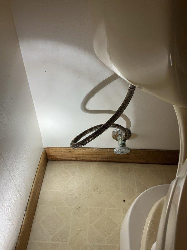 Responded to emergency dispatch for toilet water supply line leak. Upon arrival, found burst flexible supply line causing active water leak at connection point between shut-off valve and toilet tank. Shut off water supply at wall-mounted valve to stop leak and prevent further water damage. Removed failed braided supply line and inspected shut-off valve and toilet tank connection for damage or wear. Installed new flexible braided water supply line with proper threaded connections at both valve and tank inlet. Restored water supply and pressure-tested all connections to verify leak-free operation. Confirmed toilet fills properly and all plumbing connections are secure with no visible leaks.