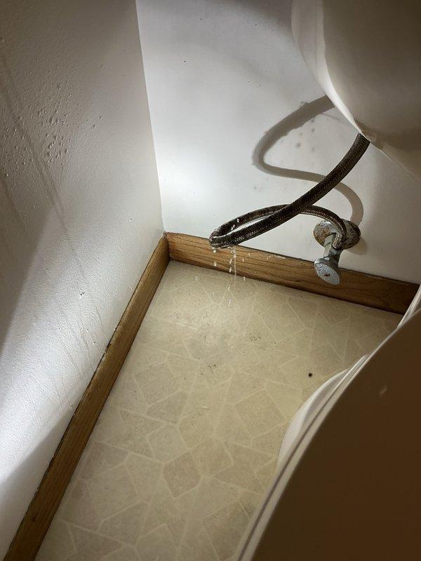 Responded to emergency dispatch for toilet water supply line leak. Upon arrival, found burst flexible supply line causing active water leak at connection point between shut-off valve and toilet tank. Shut off water supply at wall-mounted valve to stop leak and prevent further water damage. Removed failed braided supply line and inspected shut-off valve and toilet tank connection for damage or wear. Installed new flexible braided water supply line with proper threaded connections at both valve and tank inlet. Restored water supply and pressure-tested all connections to verify leak-free operation. Confirmed toilet fills properly and all plumbing connections are secure with no visible leaks.