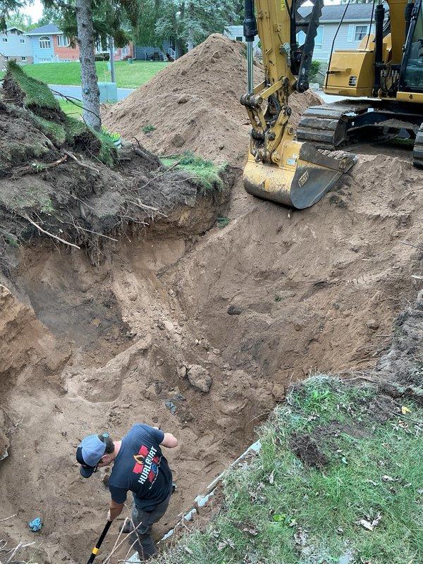 Excavated and replaced damaged sewer main line from approximately 5 feet from the house foundation to the city stub connection. Removed deteriorated pipe sections exhibiting multiple holes, failed joints, and extensive root intrusion. Installed new PVC sewer main, leaving only 5 feet of existing pipe in serviceable condition beneath the landscaping and foundation where excavation was not feasible.