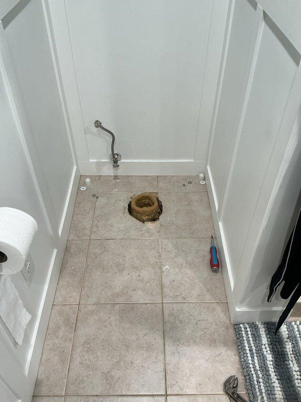 Responded to a callback for water leaking from beneath bathroom tile into floor drain following toilet replacement. Upon arrival, verified active leak concern and removed toilet to inspect installation. Discovered three to four horned wax rings improperly stacked together at the base, with toilet flange positioned below the finished tile floor level—a condition preventing proper seal formation.

Removed all existing horned wax rings and prepared flange surface. Formed a new large wax ring to compensate for the recessed flange position and installed it to create an adequate seal between the toilet base and drainage system. Applied additional wax to seal visible joints and potential leak paths around the flange connection. Reinstalled toilet, ensuring proper compression of wax ring and secure mounting to floor. Advised monitoring for any continued leakage and to contact for follow-up service if issue persists.