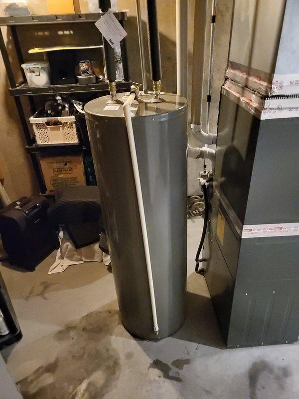 Responded to emergency call for gas water heater leaking onto basement floor. Upon inspection, identified pinhole leak at element port on aging unit of unknown manufacture date, estimated at minimum 7+ years old. Due to location and severity of leak causing active water damage to concrete floor, determined unit was not repairable and required full replacement. Removed and properly disposed of failed water heater. Installed new Bradford White residential gas water heater with appropriate venting, gas line connections, and water supply lines. Tested all connections for leaks, verified proper combustion and venting operation, and confirmed hot water delivery to fixtures. Left work area clean and operational.