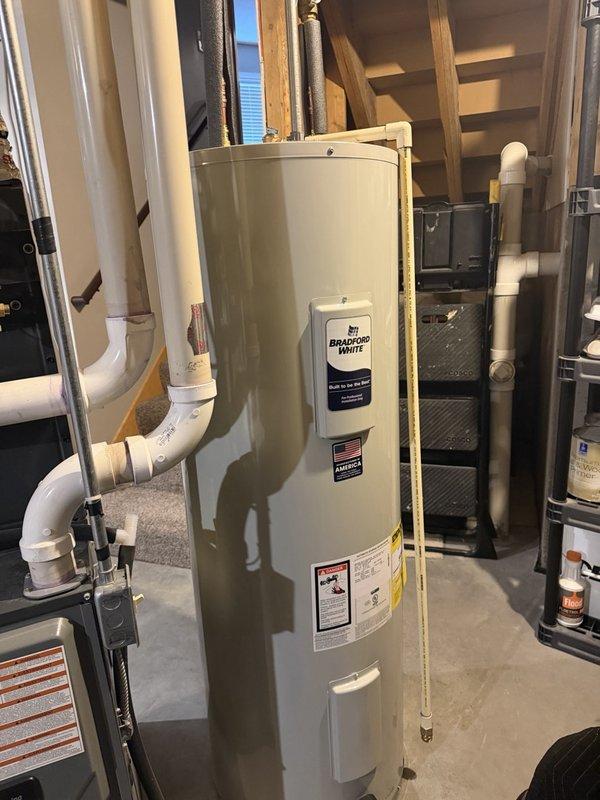 Responded to emergency call for gas water heater leaking onto basement floor. Upon inspection, identified pinhole leak at element port on aging unit of unknown manufacture date, estimated at minimum 7+ years old. Due to location and severity of leak causing active water damage to concrete floor, determined unit was not repairable and required full replacement. Removed and properly disposed of failed water heater. Installed new Bradford White residential gas water heater with appropriate venting, gas line connections, and water supply lines. Tested all connections for leaks, verified proper combustion and venting operation, and confirmed hot water delivery to fixtures. Left work area clean and operational.