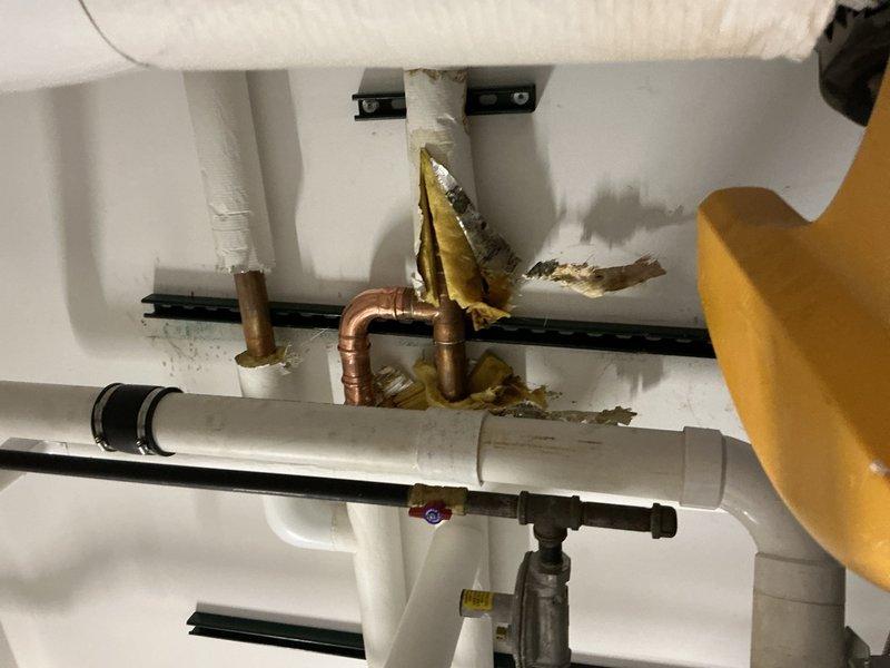 Responded to commercial water leak in main mechanical room serving three large water heaters. Upon arrival, found active leak on 1.5"-2" copper main line with insulation compromised and standing water throughout the floor area. Facility was closed at time of service, requiring coordination for building access. Identified corroded section of copper piping as source of leak, with visible oxidation and deterioration at failure point. Isolated affected section, cut out damaged copper pipe, and installed new copper section with proper fittings and connections. Tested system for proper operation and verified leak was eliminated. Noted early-stage mold growth present due to prolonged moisture exposure in mechanical room.