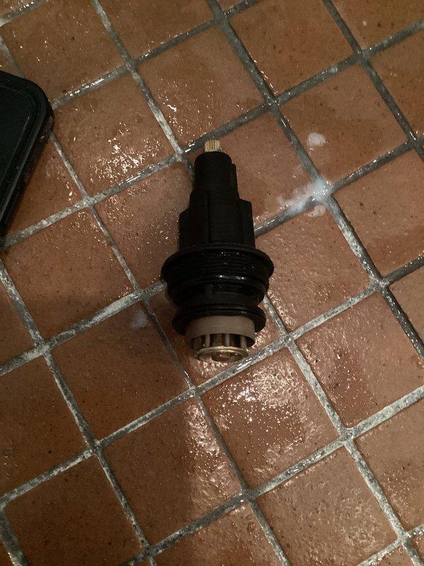 Responded to service call for malfunctioning Gerber shower valve with sticking temperature control. Upon inspection, determined that previous repair attempt had incorrectly identified the issue and only removed the backplate rather than the complete cartridge assembly. Removed and replaced the full shower cartridge (part #4251 visible on component), which had been causing intermittent temperature control problems and sticking operation. Installation includes one-year workmanship guarantee on completed repair.