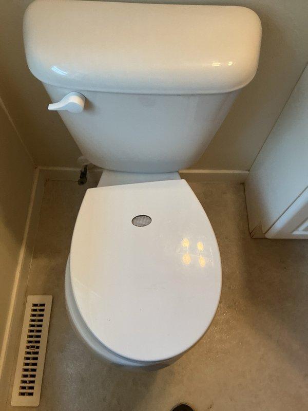Responded to service call for toilet that runs constantly after flushing, requiring manual adjustment of float to stop water flow. Upon inspection, found toilet continuously leaking water into bowl due to malfunctioning flush mechanism. Internal tank components showed significant mineral buildup and calcium deposits on fill valve assembly, with visible hard water staining throughout tank interior. Adjusted float level to temporarily reduce water flow and leakage. Due to extent of mineral deposits, age-related deterioration of internal components, and compromised flush valve operation, provided estimate options for complete toilet replacement or full internal mechanism rebuild to restore proper function and eliminate continuous running condition.