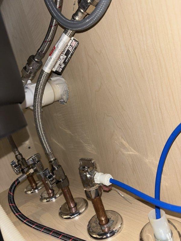 Responded to reported leak under kitchen sink. Upon arrival, found cold supply valve in closed position and reopened for inspection. Identified loose hot and cold water supply tubes at shut-off valves showing signs of previous leakage and water damage. Tightened both supply line connections at valve interface to proper torque specifications. Conducted 30-minute pressure test by running water through faucet, alternating between hot and cold supplies to verify repair integrity. No active leaks detected during testing period. Verified all connections secure and left system in full operational service.