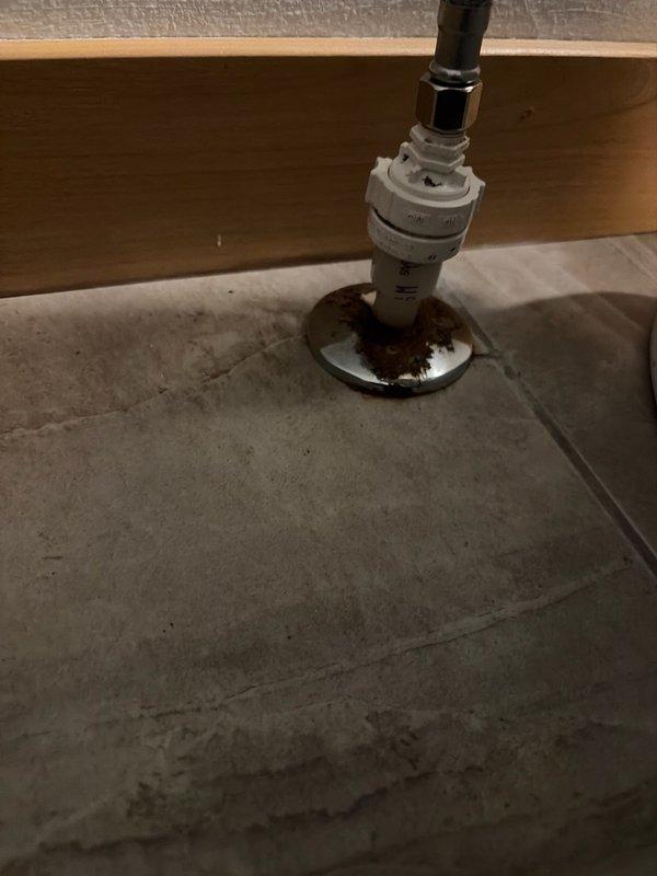 Responded to a leaking toilet supply line and defective shut-off valve. Upon inspection, found the supply line and angle stop valve actively leaking at the connection point, with visible rust-colored water damage and corrosion on the concrete floor surrounding the fixture base. The existing escutcheon plate showed significant corrosion from prolonged water exposure.

Cut out the old supply line and removed the corroded escutcheon. Installed a new standard angle stop shut-off valve with proper sealing to prevent future leaks. Installed a new escutcheon plate to provide a finished appearance and protect the floor penetration. Tested the new installation for proper operation and verified no leaks were present at connections. Left the fixture fully functional with reliable water shut-off capability restored.
