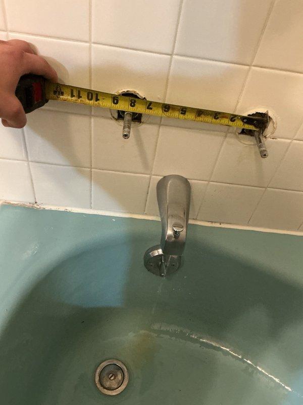 Responded to bathtub faucet leak in owner-occupied residence. Upon inspection, identified dripping from both the tub spout and cold water handle of vintage three-handle faucet assembly mounted on tiled wall above green bathtub. Measured existing fixture spacing and documented worn components showing signs of age and deterioration. Completed part order form to procure replacement parts for repair of leaking faucet components.