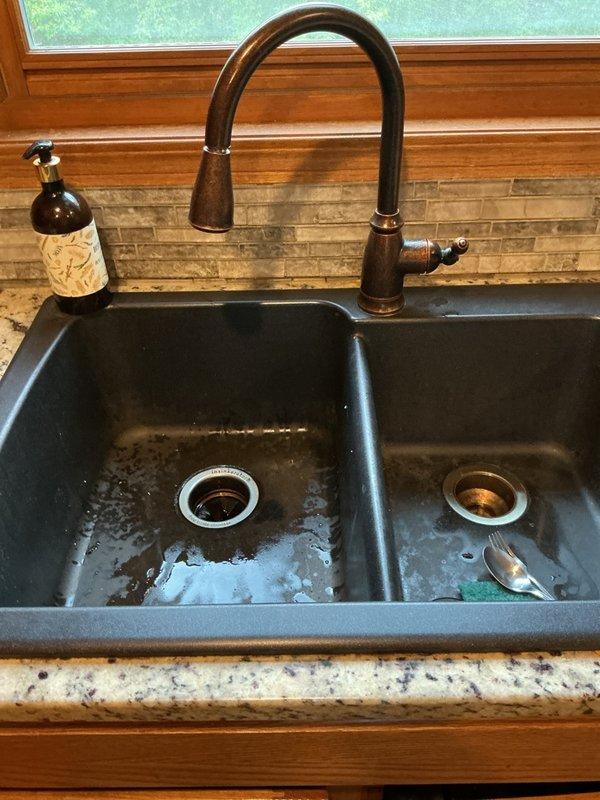 Responded to service call for kitchen sink and dishwasher drainage issue. Upon arrival, found double-basin kitchen sink experiencing backup with dishwasher failing to drain properly. Performed diagnostic assessment of drainage system and identified blockage affecting both fixtures. Cleared obstruction from drain line, restoring proper flow and drainage function. Verified dishwasher now draining correctly with no standing water remaining in unit. Conducted water softener inspection as part of scheduled maintenance check. Tested all affected fixtures to confirm complete resolution of drainage problem and proper operation of plumbing system.