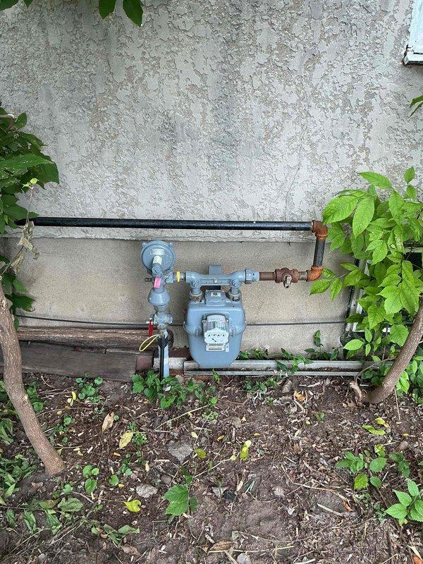 Responded to gas leak emergency at residential property where utility company had shut off gas supply and marked leak location at exterior meter elbow on southeast side of structure. Upon arrival, coordinated access through designated contact and conducted thorough inspection of exterior gas supply system and meter assembly. Identified locked gas meter and discovered multiple leak points beyond the initially marked elbow connection, requiring comprehensive assessment of the gas piping system. Documented all findings with photographic evidence showing exterior meter installation with corroded piping, connections, and fittings, as well as interior Richmond water heater and associated gas appliances. Determined that air pressure testing of the entire gas supply line system would be necessary to accurately identify all leak locations and assess the full extent of required repairs. Communicated findings to property owner by phone for approval to proceed with diagnostic air testing and provi
