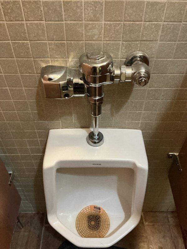 Responded to commercial restroom facilities for toilet leak and urinal flushing malfunction. In the ladies' room, diagnosed failed wax ring causing water leakage at toilet base; removed toilet, replaced wax seal, and properly reset unit to eliminate leak. In the men's room, identified defective automatic flushometer on wall-mounted Kohler urinal preventing proper flush operation; removed faulty sensor-operated flush valve and installed new manual flushometer assembly to restore full functionality.