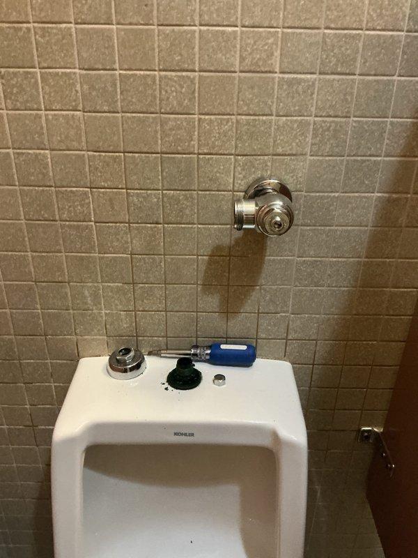 Responded to commercial restroom facilities for toilet leak and urinal flushing malfunction. In the ladies' room, diagnosed failed wax ring causing water leakage at toilet base; removed toilet, replaced wax seal, and properly reset unit to eliminate leak. In the men's room, identified defective automatic flushometer on wall-mounted Kohler urinal preventing proper flush operation; removed faulty sensor-operated flush valve and installed new manual flushometer assembly to restore full functionality.