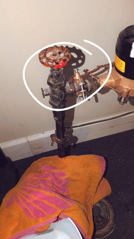 Responded to a dripping water leak originating from a valve on the main water supply line in the basement. Upon inspection, identified a faulty angle valve in the plumbing assembly requiring replacement. Temporarily shut off the main water service to prevent further water damage and documented the existing configuration, which included a red-handled gate valve and multiple connection points showing signs of age and oxidation. Researched and sourced appropriate replacement part—a NIBCO NL-NK008 T-311-Y bronze angle valve with 3/4" NPT threading and handwheel actuator—and prepared a detailed estimate for the valve replacement work.