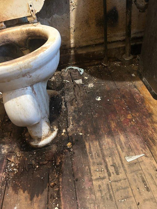 Responded to emergency water leak call involving deteriorated toilet causing extensive water damage to bathroom flooring and subfloor structure. Upon inspection, found very old toilet with active leak that had been present for extended period, resulting in severe moisture damage to wooden floor, subflooring, and adjacent crawl space area. Documented extensive deterioration including heavily stained flooring, compromised structural wood members, and water infiltration beneath bathroom. Assessed damage and provided recommendations for necessary repairs including toilet replacement and floor reconstruction. Waived diagnostic fee due to customer circumstances.