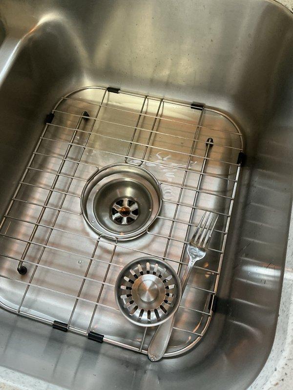 Responded to slow-draining kitchen and bathroom sinks with backup issues. Located blockage caused by hair and grease accumulation at 45 or 90-degree fitting in drain line. Successfully cleared obstruction using small rigid cable machine, restoring proper drainage to all affected fixtures.