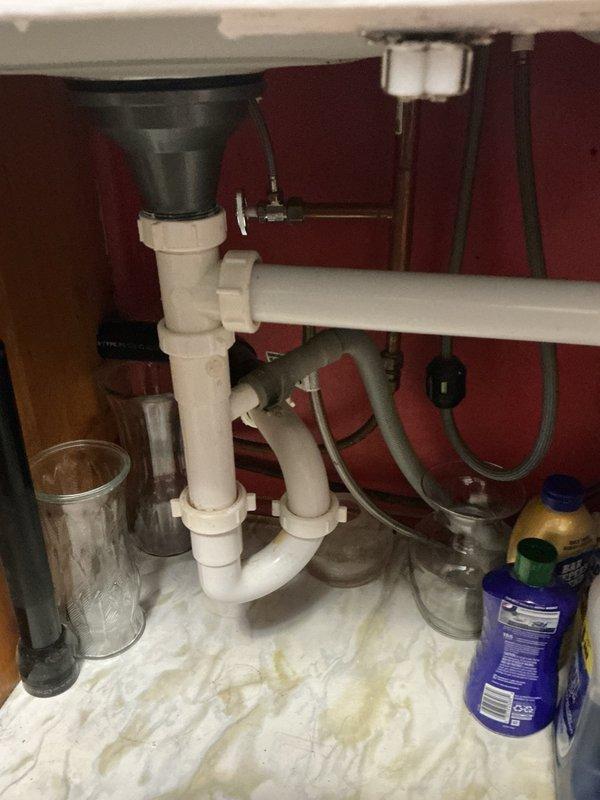 Responded to slow-draining kitchen and bathroom sinks with backup issues. Located blockage caused by hair and grease accumulation at 45 or 90-degree fitting in drain line. Successfully cleared obstruction using small rigid cable machine, restoring proper drainage to all affected fixtures.