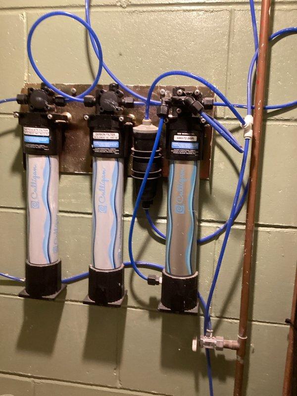 Completed recurring plumbing inspection of residential property. Identified and resolved whistling noise issue in toilet caused by defective fill valve; removed old fill valve and installed new replacement unit. Inspected and documented water filtration system consisting of three Culligan filter units with proper mounting and blue tubing connections in utility area, confirming operational status of all components.