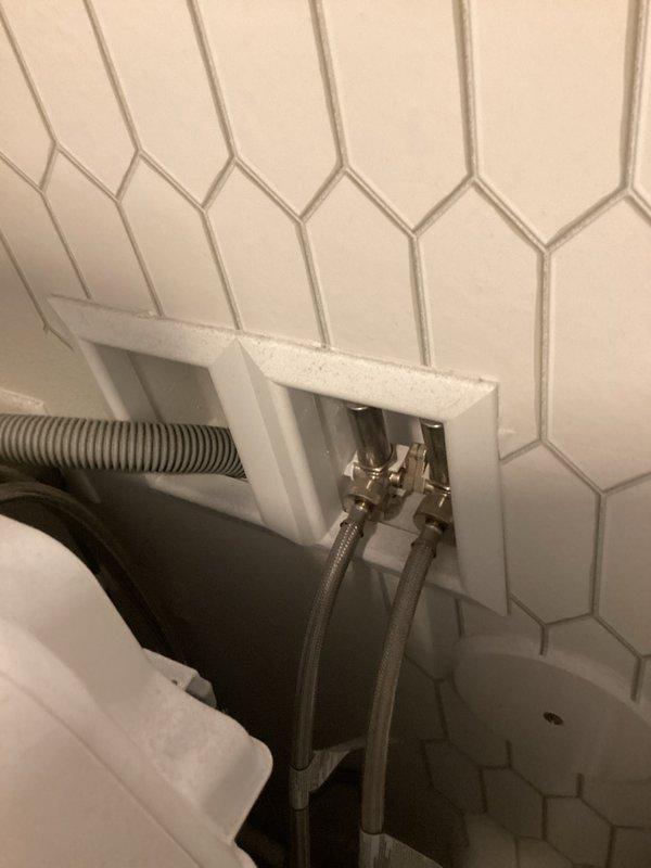 Completed comprehensive plumbing inspection of residential property. Evaluated bathroom plumbing installation including wall-mounted water supply connections with braided metal supply lines and access panel in hexagonal tile surround. Inspected whole-house water treatment system consisting of dual-tank water softening and filtration equipment with digital control units, verified proper operation of system components, and confirmed all plumbing connections and PVC piping were secure and functioning correctly.