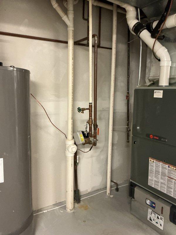 Responded to water leak spraying from shower arm pipe extending from wall. Upon inspection, discovered damaged and smashed threads on existing shower arm preventing proper seal. Removed defective shower arm and found threads severely compromised, requiring partial thread removal to achieve clean connection surface. Installed replacement shower arm and restored proper water flow to dual-head black shower system without leakage.