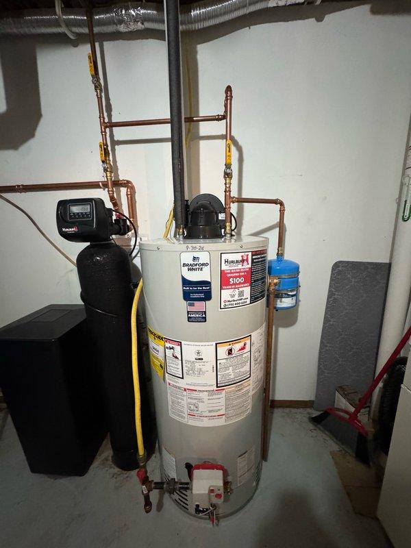 Upgraded residential water system by removing existing 202 model 20-gallon pressure tank and installing new 203 model 30-gallon pressure tank with new gooseneck fitting. Reconfigured copper piping connections to accommodate larger tank capacity and ensured proper integration with existing water heater and treatment system. All connections tested and system restored to full operation.
