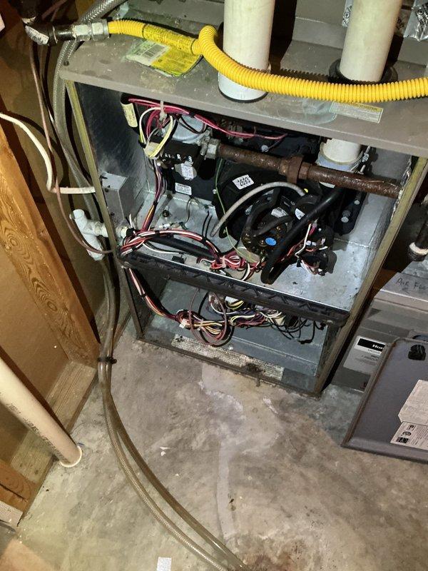 Responded to no heat call on 18-year-old furnace system. Upon arrival, confirmed blower fan was activating but furnace failed to ignite. Performed diagnostic inspection and identified failed draft inducer motor as root cause of system failure. Draft motor showed no operation when heating cycle was called for, preventing proper venting and safety lockout of ignition sequence. 

Documented existing system conditions including significant corrosion on gas piping and general age-related wear throughout unit. Explained findings and repair options to property owner via phone communication, as this was a rental property with owner off-site. Given the age of the equipment at 18 years and the cost of draft motor replacement, recommended comfort advisor consultation to evaluate repair versus replacement options. Provided photographic documentation of failed component and overall system condition for owner review and decision-making purposes.