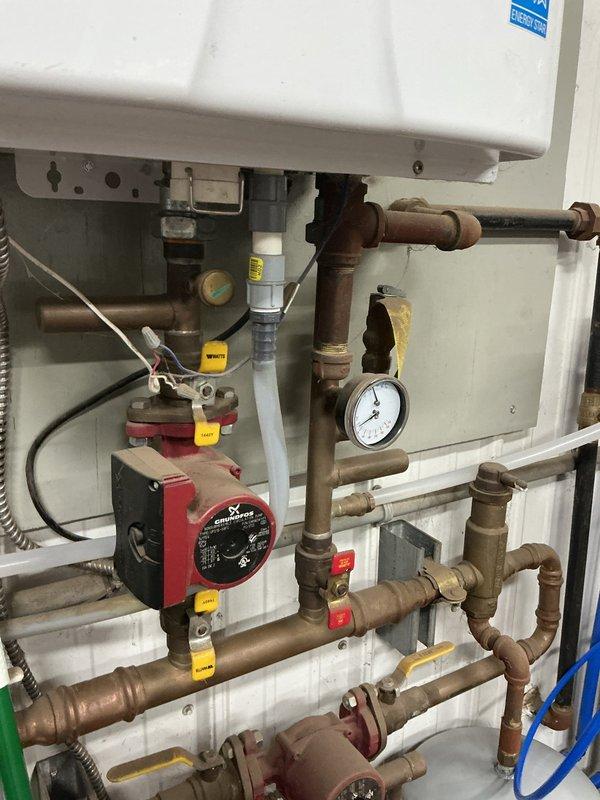 Responded to second callback for water leak at pipe junction in hydronic heating system. Upon inspection, identified leaking trap assembly where drain pipes connected. Water was pooling at connection point and actively dripping. Disassembled trap, inspected components for damage or deterioration, and replaced faulty washers and compression fittings. Reassembled trap with proper sealing, tested system under pressure to verify repair integrity. No further leaks detected at junction or surrounding copper piping connections. System returned to normal operation.