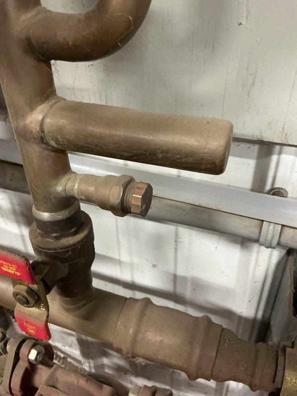 Responded to second callback for water leak at pipe junction in hydronic heating system. Upon inspection, identified leaking trap assembly where drain pipes connected. Water was pooling at connection point and actively dripping. Disassembled trap, inspected components for damage or deterioration, and replaced faulty washers and compression fittings. Reassembled trap with proper sealing, tested system under pressure to verify repair integrity. No further leaks detected at junction or surrounding copper piping connections. System returned to normal operation.