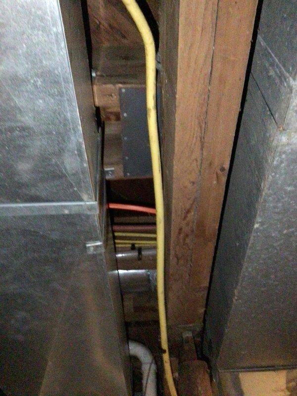 Performed comprehensive furnace tune-up on both units of a duplex property in response to reported gas odor concerns. Upon inspection, confirmed both furnaces were operating properly but discovered a pinhole leak in the gas-tight supply line. Documented the compromised gas line with photos showing the yellow gas line routing through the attic space and created an estimate for complete gas line replacement from the furnace connections to the exterior regulator to ensure safe operation and eliminate the gas leak hazard.