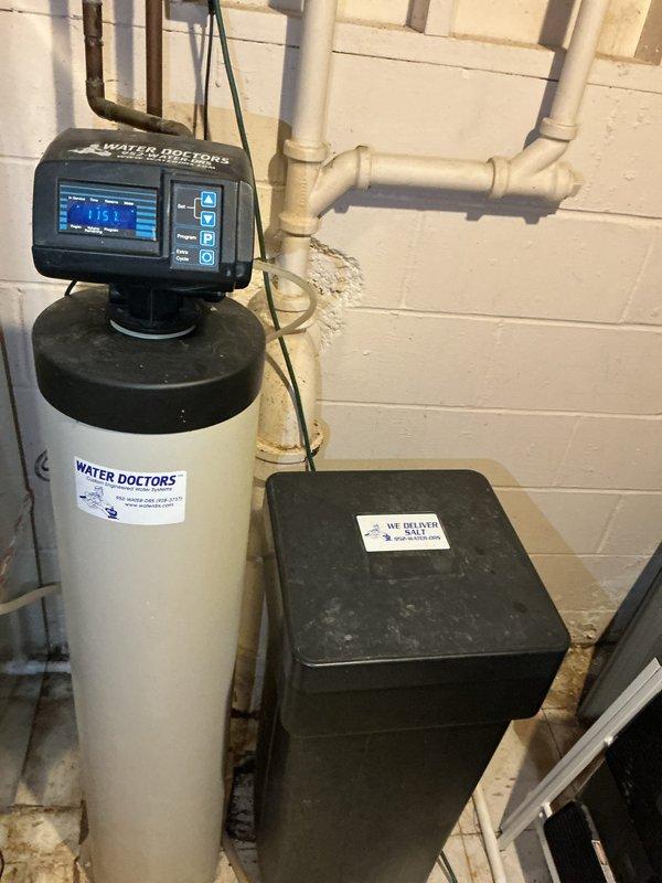 Responded to service call for multiple plumbing concerns including water heater maintenance, leak investigation, and water system upgrades. Performed complete flush and inspection of tanked water heater to address reported leak and ensure optimal performance. Evaluated exterior building leak to determine source and extent of water intrusion. Conducted thorough inspection of existing Water Doctors water softener system with digital control head, verifying proper operation of softener tank, brine tank, and control settings before extended property vacancy period. Successfully installed Moen Flo smart water detection and automatic shut-off valve system on main water line, integrating leak detection technology with existing plumbing infrastructure to provide whole-house water monitoring and emergency shut-off capability. Installation included mounting control unit, connecting to water supply line, and configuring system for remote monitoring. All plumbing connections tested and verified le