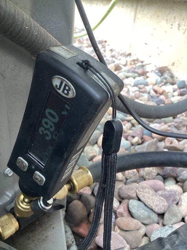 Responded to no cooling complaint and found compressor terminal blown off. Replaced failed compressor under parts warranty, ensuring proper refrigerant recovery and system evacuation prior to installation. Cleaned condenser coil thoroughly and removed oil stains from condenser unit exterior. Performed system startup, verified proper operating pressures at 390 PSI as shown on digital gauge, and confirmed adequate cooling performance. Unit restored to full operational status.