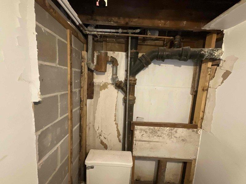 Responded to first call priority service window for vacant property requiring multiple plumbing installations. Assessed existing plumbing infrastructure in lower level utility area, noting aged copper piping and deteriorated conditions throughout unfinished basement space. Documented pre-existing conditions including exposed concrete block walls, compromised paint surfaces, and aging mechanical systems requiring attention prior to installation work. Coordinated arrival time with property owner and confirmed scope of work including main floor toilet and pedestal sink installation, shower faucet replacement, dishwasher hookup preparation, and exterior lower level spigot installation. Photographic documentation completed showing existing plumbing conditions and workspace layout to establish baseline for renovation project proceeding in conjunction with scheduled electrical contractor work.