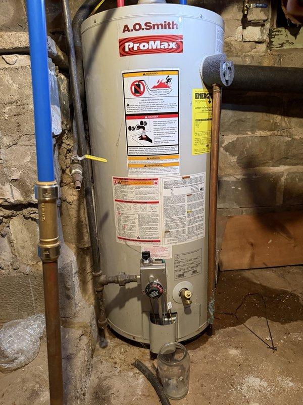 Responded to service call for leaking water heater. Upon inspection, confirmed active leak from existing tank-style water heater requiring immediate replacement. Removed and disposed of failed unit, then installed new A.O. Smith ProMax tank water heater in basement utility area. Connected all supply and discharge lines including PEX and copper piping, installed appropriate shut-off valves, and verified proper temperature and pressure relief valve operation. System tested and confirmed operational with no leaks detected.